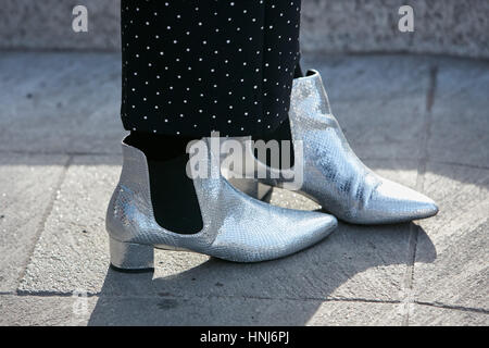 Woman with silver boots and polka dot trousers before Emporio Armani fashion show, Milan Fashion Week street style on January 14 Stock Photo