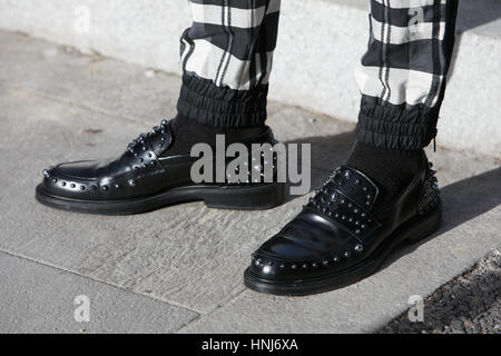 Man with black leather shoes with studs and checkered trousers before Salvatore Ferragamo fashion show, Milan Fashion Week street Stock Photo