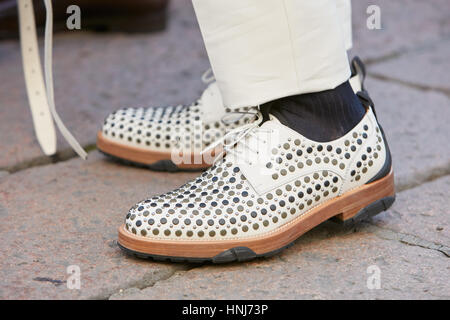 Man with white leather shoes with studs before Salvatore Ferragamo fashion show, Milan Fashion Week street style on January 15, 2017. Stock Photo
