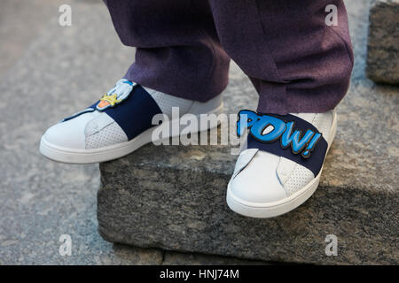 Man with purple trousers and comic writing Pow on white shoes with before Salvatore Ferragamo fashion show, Milan Fashion Week. Stock Photo