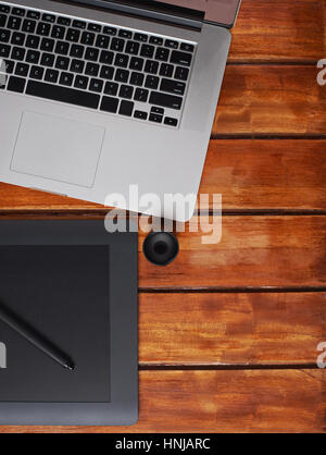 designer wood desk with modern laptop and graphic tablet vertical orientation Stock Photo