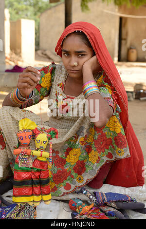 BHUJ, RAN OF KUCH, INDIA - JANUARY 14: The tribal woman in the traditional dress selling souvenirs for tourists in the ethnic village on the desert in