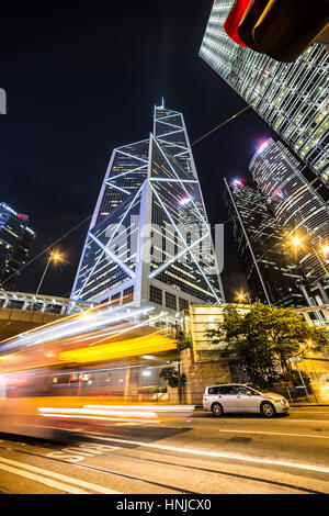 HONG KONG - JANUARY 6 2016: A bus rushes in the heart of Hong Kong business district in the Admiralty area in Hong Kong island at night Stock Photo