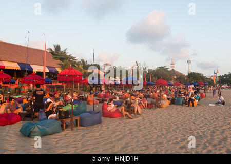 BALI, INDONESIA - OCTOBER 31, 2015: Tourists enjoy a drink while waiting for the sunset in a beach bar along Seminyak beach, just north of Kuta, in Ba Stock Photo