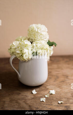 White lilac bouquet laid on wooden table. Studio shot. Stock Photo