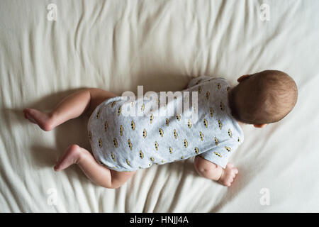 Cute newborn baby boy lying on bed, close up Stock Photo