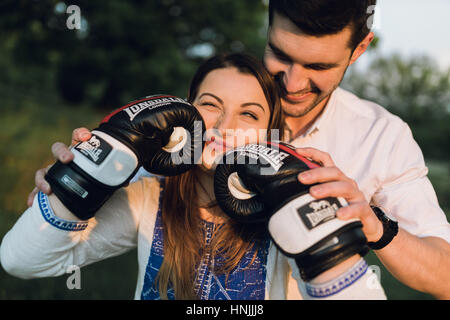 Young couple having fun with black boxing gloves, making funny faces Stock Photo