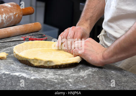 Baker kneading dough for tart in a bakery Stock Photo