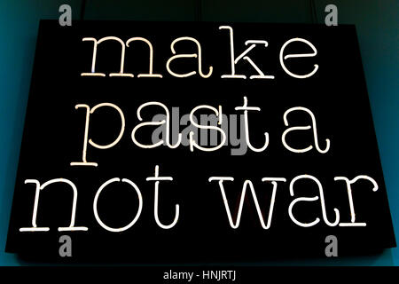 Make pasta not war. Concept ironic peace message against war, in favour of pasta. White neon sign on black background. Stock Photo