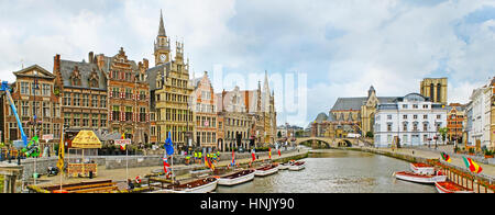 GHENT, BELGIUM - MAY 26, 2011: Panorama of the medieval stepped gable mansions at the Graslei Quay of Leie River with numerous tourist boats and the v Stock Photo