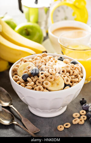 Healthy cold cereal with banana and blueberry in a white bowl, quick breakfast or snack for children Stock Photo