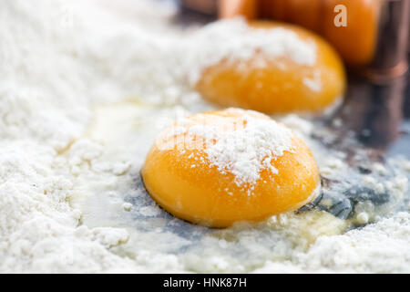 close up of two egg yolks in flour ,focus on the foreground shot with narrow depth of field to ad copy space Stock Photo