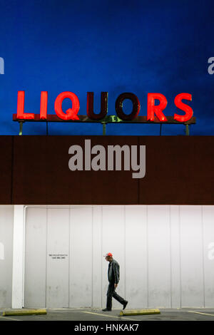 A man walks past a liquor store in downtown Las Vegas. Stock Photo