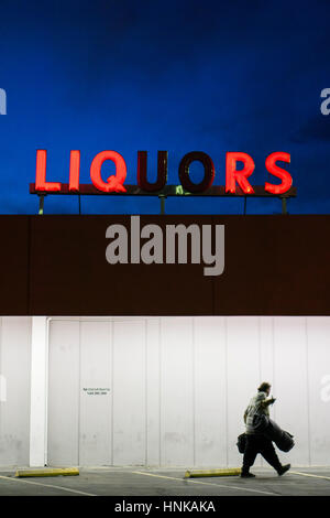 A man walks past a liquor store in downtown Las Vegas. Stock Photo