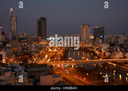 Apartments, Bitexco Financial Tower, high rise buildings, and traffic beside Ben Nghe River, Ho Chi Minh City (Saigon), Vietnam Stock Photo
