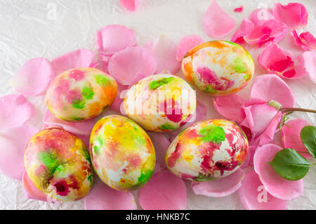 Painted Easter egg placed on pink rose petals Stock Photo