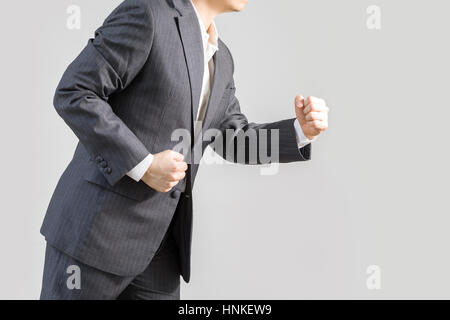 Studio shot of businessman in rush running forward, isolated on white background, illustrating success concept. Stock Photo