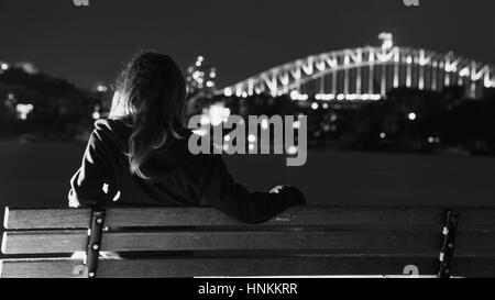 Girl sitting admiring view of Sydney harbour from cockatoo island Stock Photo
