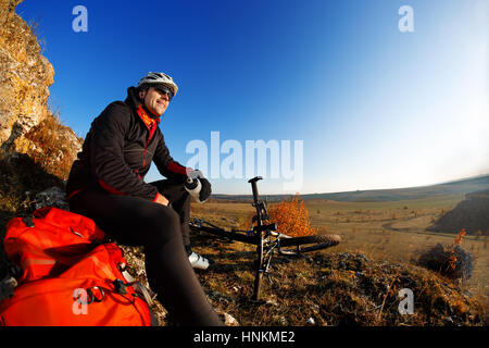 Man in a bike helmet makes a break. Stock Photo