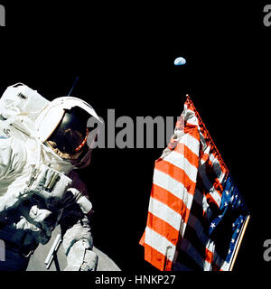 Scientist-astronaut Harrison H. Schmitt stands by the American flag during a moonwalk on the Apollo 17 mission. Home, that small dot in the blackness of space above the flag, is a quarter-million miles away.  Schmitt, Gene Cernan and Ron Evans made the Apollo program's final journey to the moon in December 1972.  Photo Credit: NASA Stock Photo