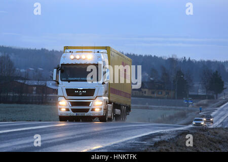 SALO, FINLAND - JANUARY 1, 2017: Stylish white MAN TGX 18.480 truck customized with lighting accessories hauls DHL trailer along highway on a blue win Stock Photo