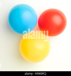 upper view of three balloons red blue and yellow on white background Stock Photo