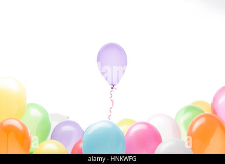 concept image of a balloon rising from his colorful group, white background Stock Photo