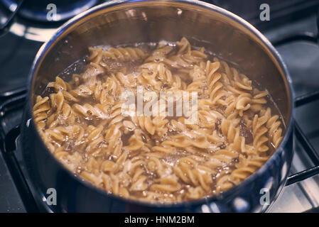 Boiling Wholemeal Pasta cooking in a saucepan on the stove Stock Photo