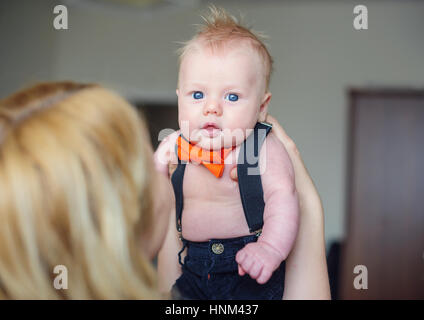 Mom holding the baby in her arms and looks at him Stock Photo