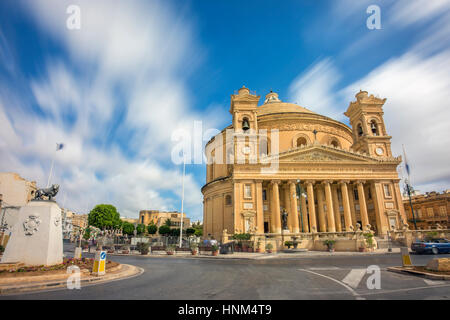 Mosta, Malta - The Church of the Assumption of Our Lady, commonly known as the Rotunda of Mosta or Mosta Dome at daylight with moving clouds Stock Photo