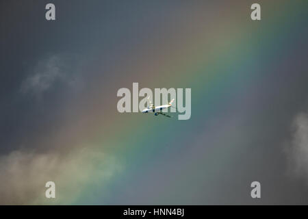 London, UK. 15th Feb, 2017. UK Weather: A British Airways Embraer ERJ-190SR jet leaving City Airport passes through a massive colourful rainbow over the city. Credit: Guy Corbishley/Alamy Live News Stock Photo