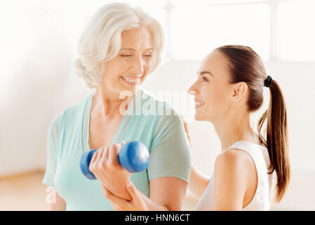 Nice fitness coach helping the elderly woman Stock Photo
