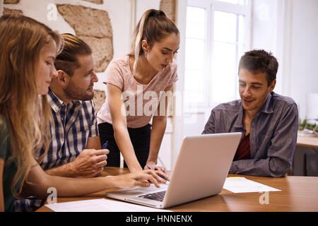 Presenter looking down thoughtfully at explanation one of the business team is illustrating during a meeting of a professional team building group Stock Photo