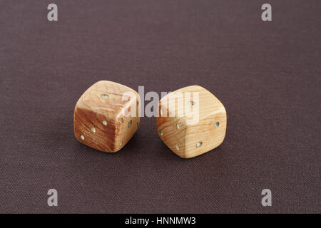 Two wooden dices with number one on the top on purple cloth Stock Photo