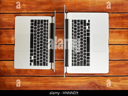 Two modern laptops on wooden table view from top Stock Photo