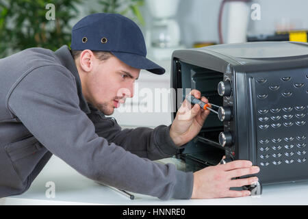 Man repairing counter top oven Stock Photo