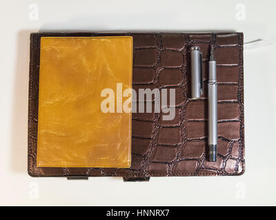The notepads, purses and metal pen on white background Stock Photo