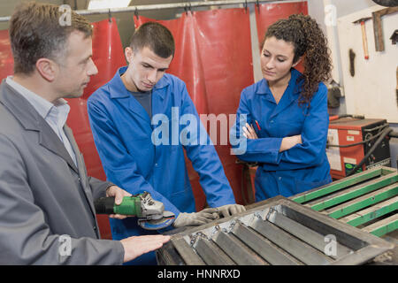 apprentices watching teacher in workshop Stock Photo