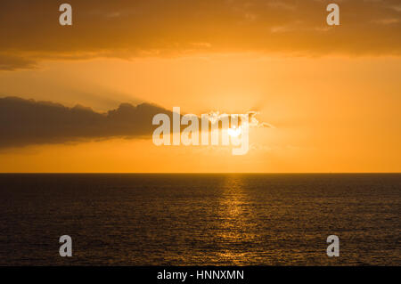 Wonderful sunset at over, partly hidden sun by clouds Stock Photo