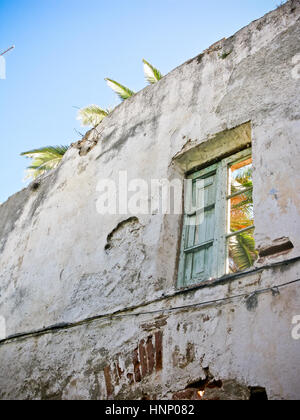 Old shabby ruined abandoned brick building wall facade with two wooden ...