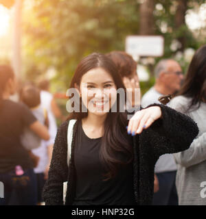 Woman enjoying Butterfly perched on her hand at the park Stock Photo