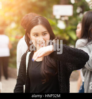 Woman enjoying Butterfly perched on her hand at the park Stock Photo