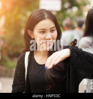 Woman enjoying Butterfly perched on her hand at the park Stock Photo