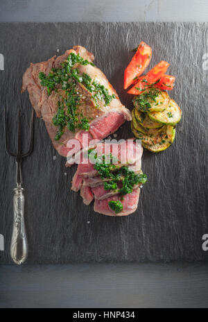 Roast Beef dinner with roasted zucchini, pepper and salsa verde Stock Photo