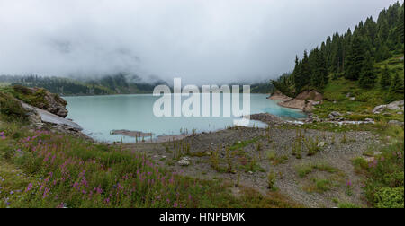 thick white mist over the Big Almaty Lake, large natural reservoir of fresh water Stock Photo