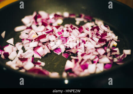 chopped red onion in a frying pan Stock Photo