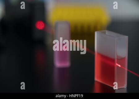 Quartz cuvette for laser chromatography with red liquid. Physical chemistry laboratory Stock Photo