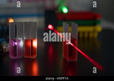 Quartz cuvette for laser chromatography with red liquid. Physical chemistry laboratory Stock Photo