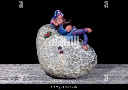 UMEA, SWEDEN ON SEPTEMBER 18, 2013. A handmade figure of modeling clay on a stone. Black background. Illustrative Editorial. Stock Photo