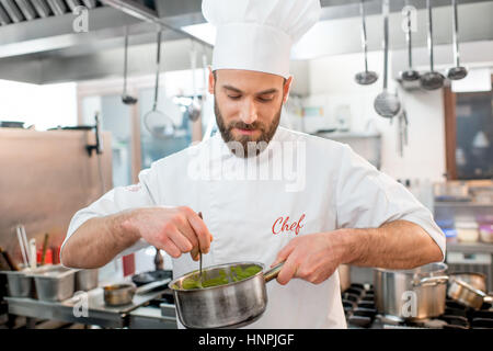 Handsome chef cook making sause at the restaurant kitchen Stock Photo